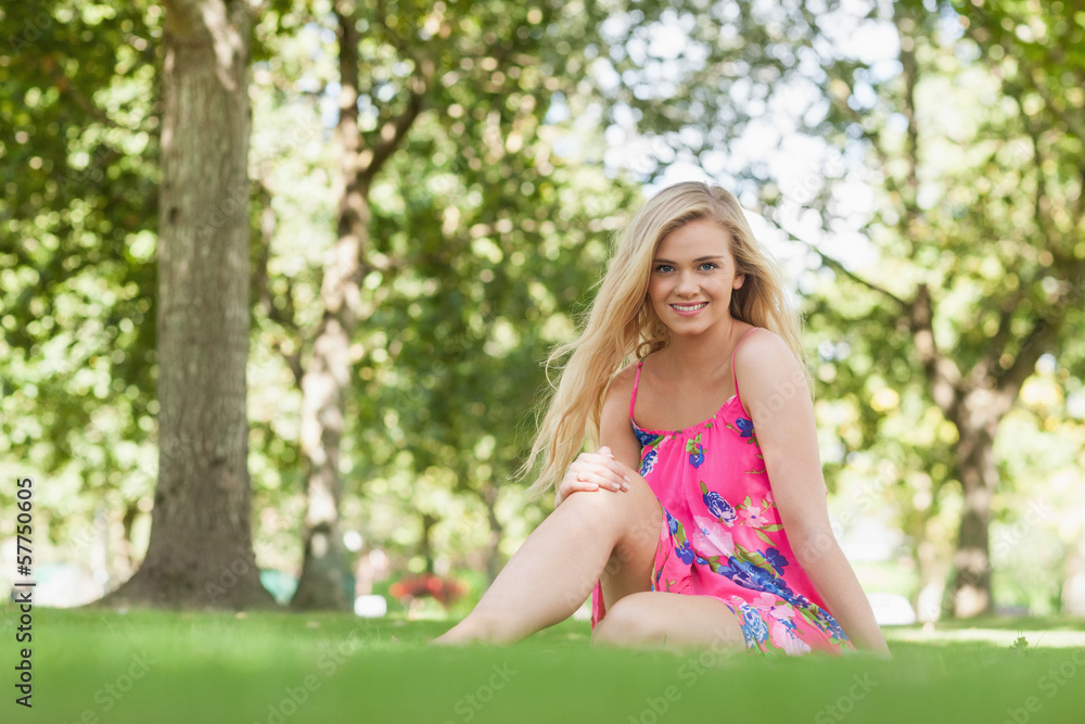 Naklejka premium Content blonde woman sitting in a park