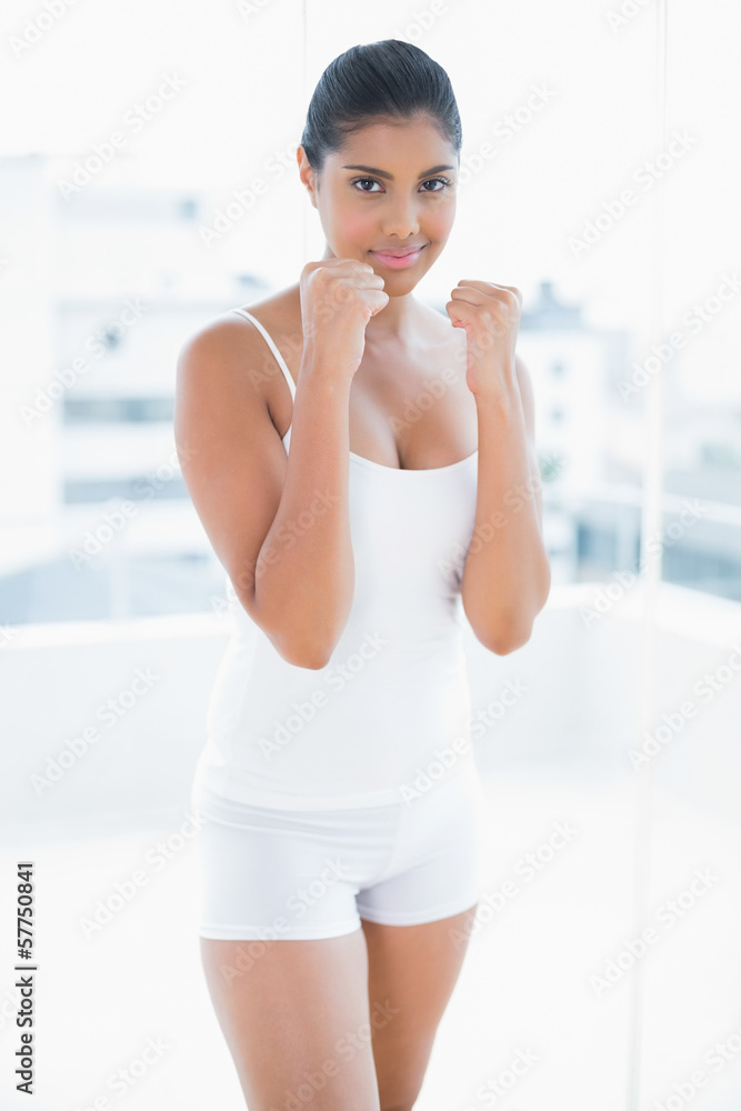 Smiling toned brunette standing with lifted fists