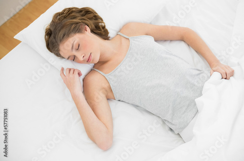 Calm slender woman lying sleeping on her bed under the cover