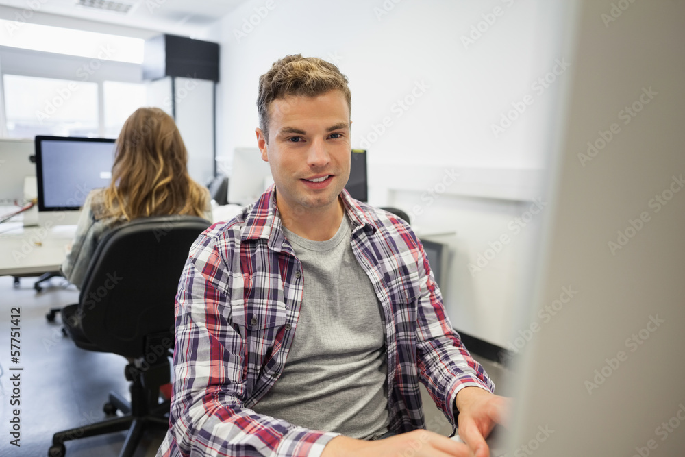 Handsome smiling student working on computer Handsome smiling student working on computer