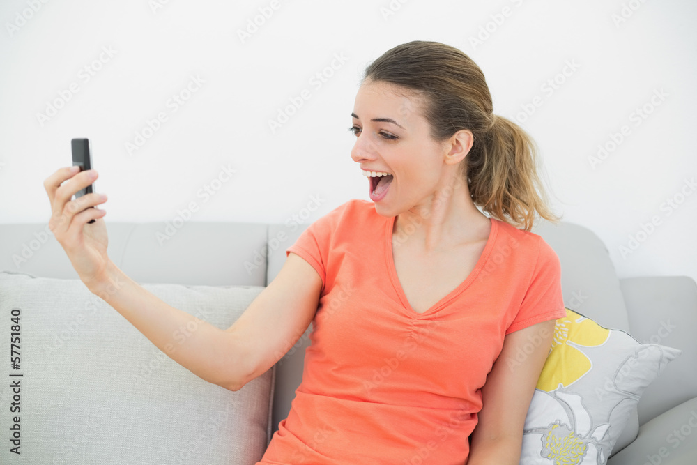 Surprised casual woman looking at her smartphone Surprised casual woman looking at her smartphone