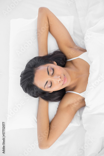 Peaceful young woman sleeping lying on her bed