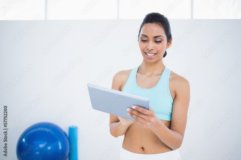 Smiling dark haired woman using her tablet Smiling dark haired woman using her tablet