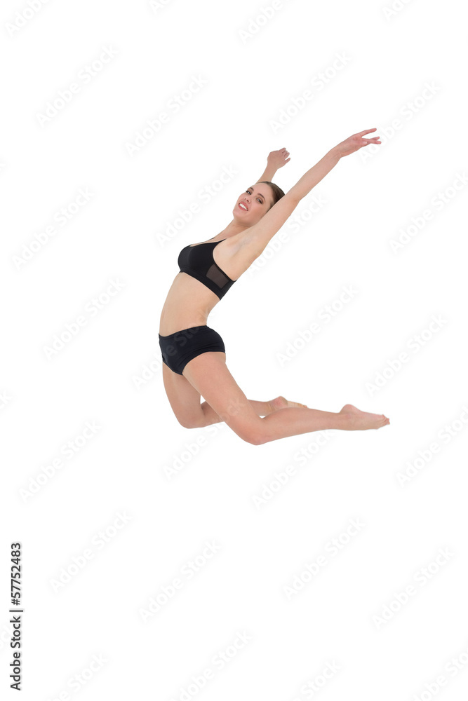 Side view of a sporty woman jumping on white background