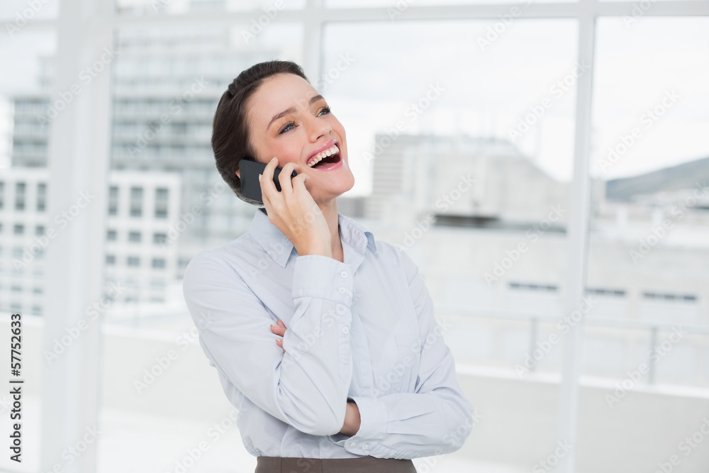 Cheerful businesswoman using cellphone in office Cheerful businesswoman using cellphone in office