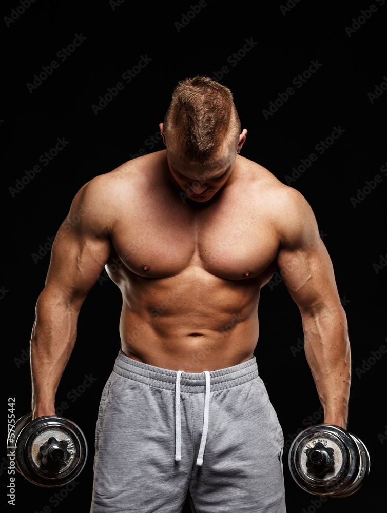 Handsome young muscular man exercising with dumbbells Handsome young muscular man exercising with dumbbells