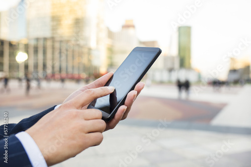 Businesswoman sending messages with her smart phone
