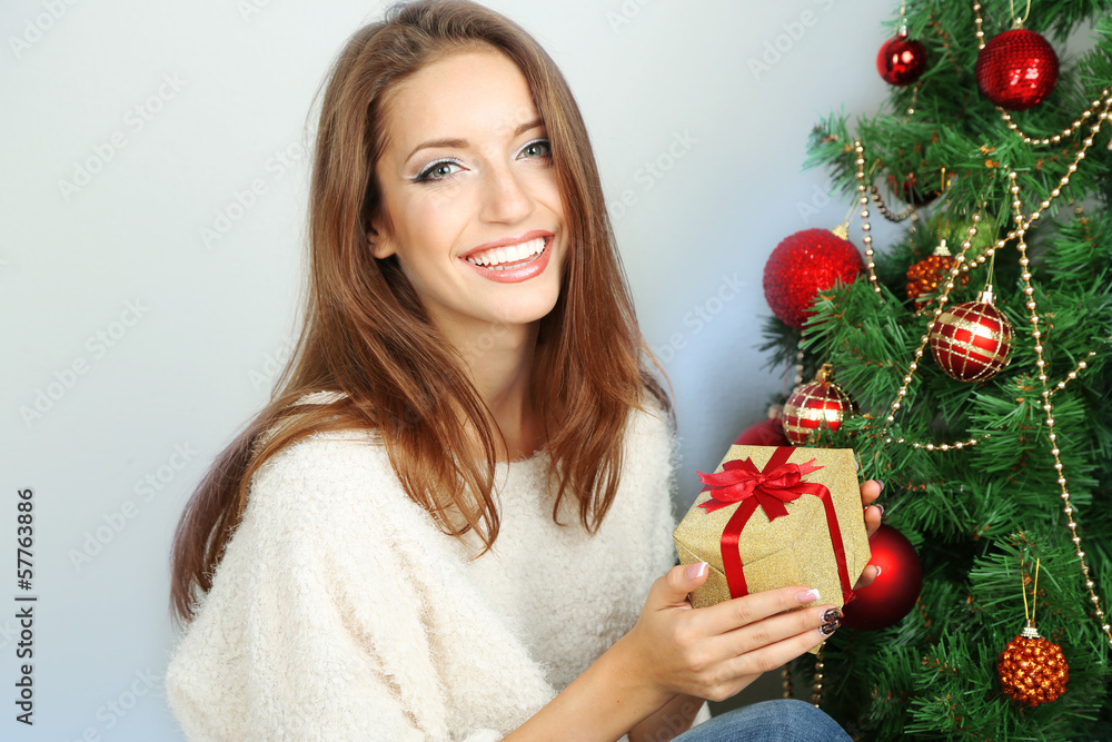 Beautiful girl near Christmas tree with gift Beautiful girl near Christmas tree with gift