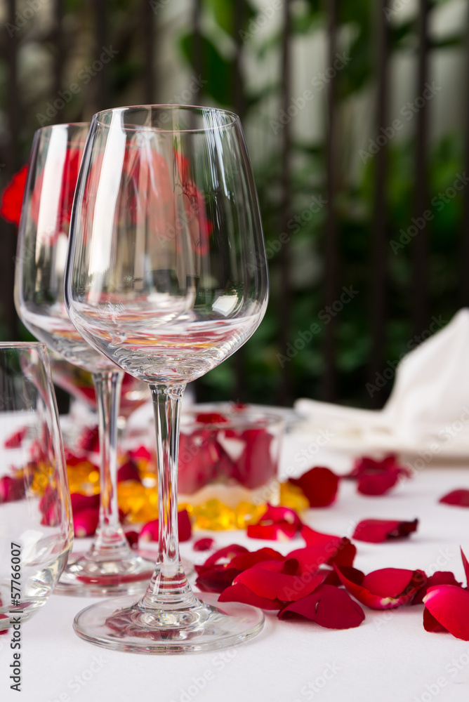 Wine glass table set with rose petals decorations Stock Photo