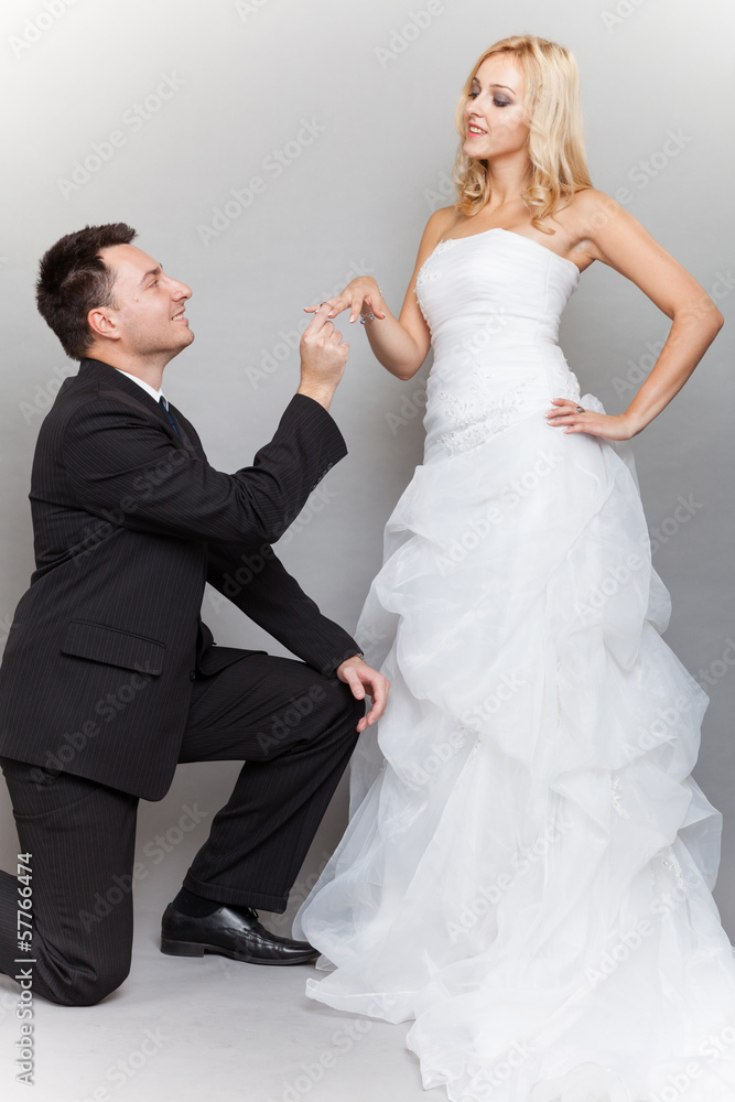 Groom putting a wedding ring on bride's finger