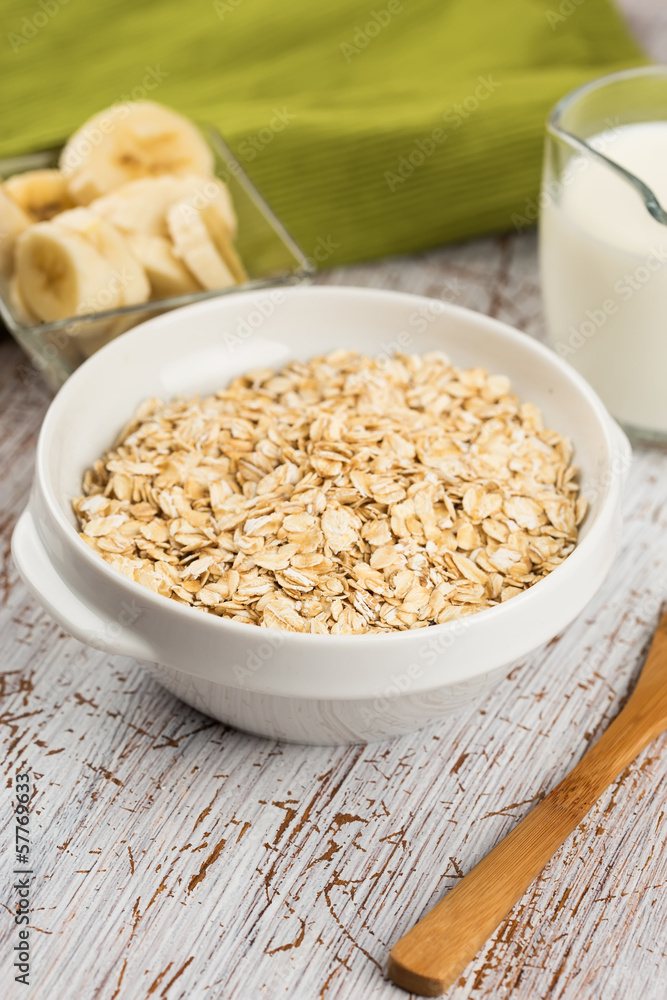 Oat flakes in bowl with banana and milk Oat flakes in bowl with banana and milk