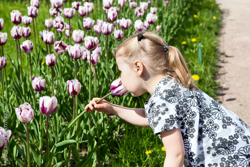 Small girl in summer dress smelling pink tulips Small girl in summer dress smelling pink tulips