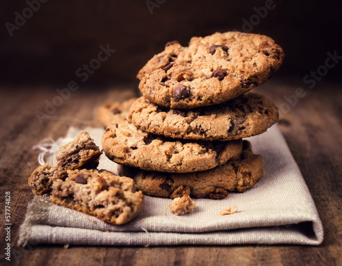 Chocolate chip cookies on linen napkin on wooden table. Stacked