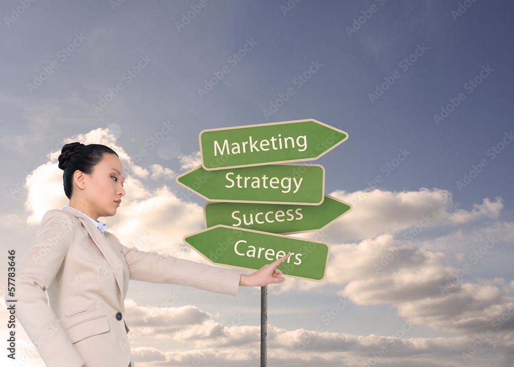 Composite image of unsmiling asian businesswoman pointing Composite image of unsmiling asian businesswoman pointing
