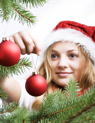 Mädchen schmückt Weihnachtsbaum