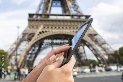 Woman using her Smart phone in front of Eiffel Tower