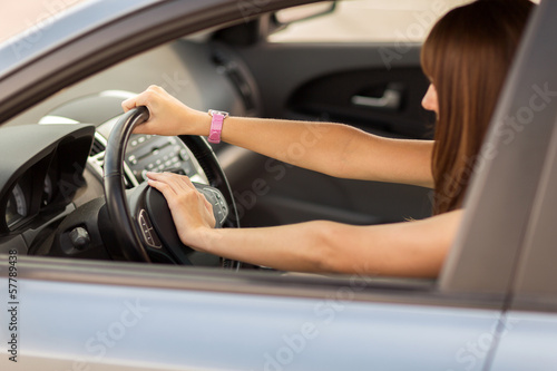 woman driving a car with hand on horn button