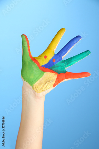 Painted hand with smile on blue background