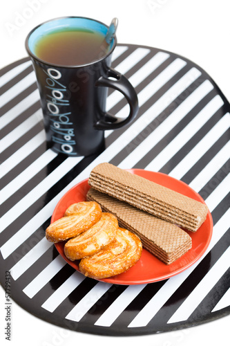 A cup of tea, cakes and wafer photo