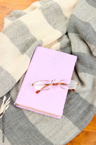 Composition with old book, eye glasses and plaid