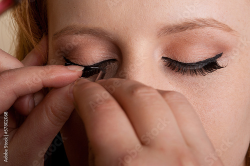 Professional makeup artist artist applies false eyelashes © Terence Mendoza
