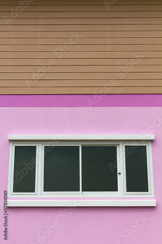 Pink walls with white opaque glass window under brown wood