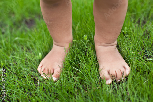 Small cute baby feet on the grass.