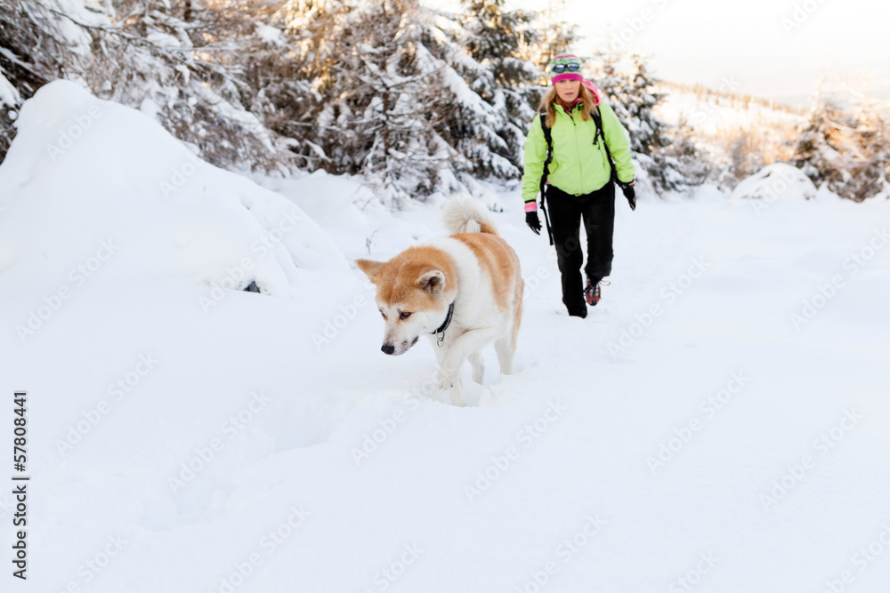 Woman winter hiking with dog