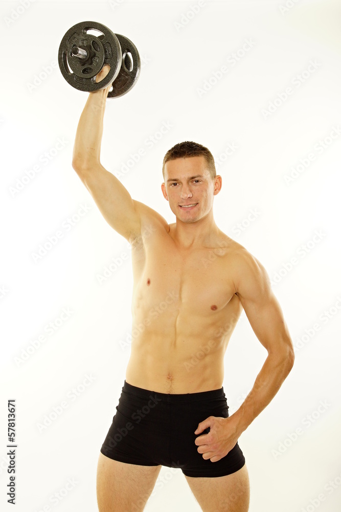 Young man exercises with dumbbell over head. Young man exercises with dumbbell over head.