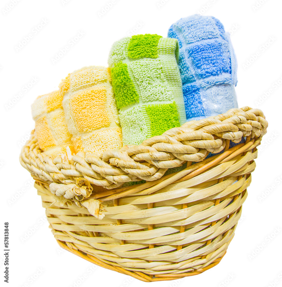 Rolls of different colors of towels in a wicker basket.