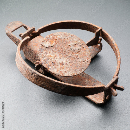 Rusty trap isolated on grey background photo