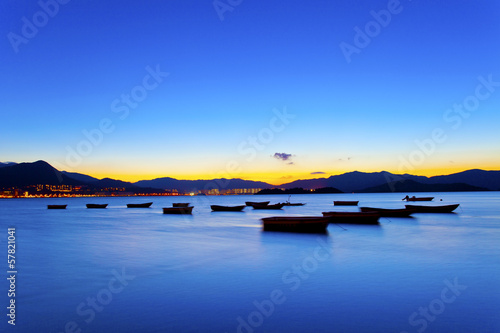 Sunset view by the coast with boats © Jess Yu