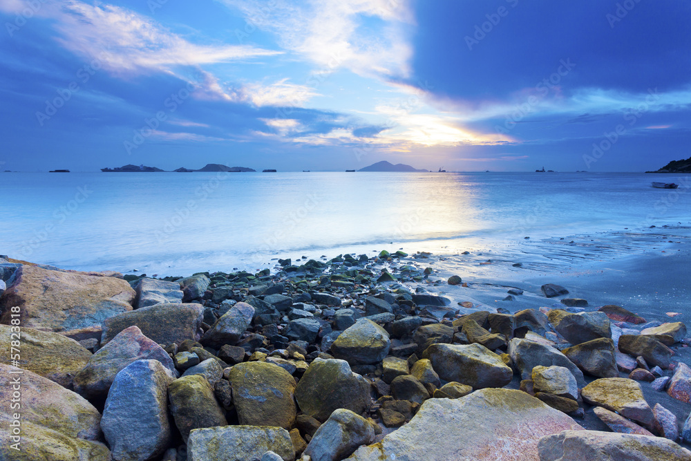 Sunset coast with sea stones background