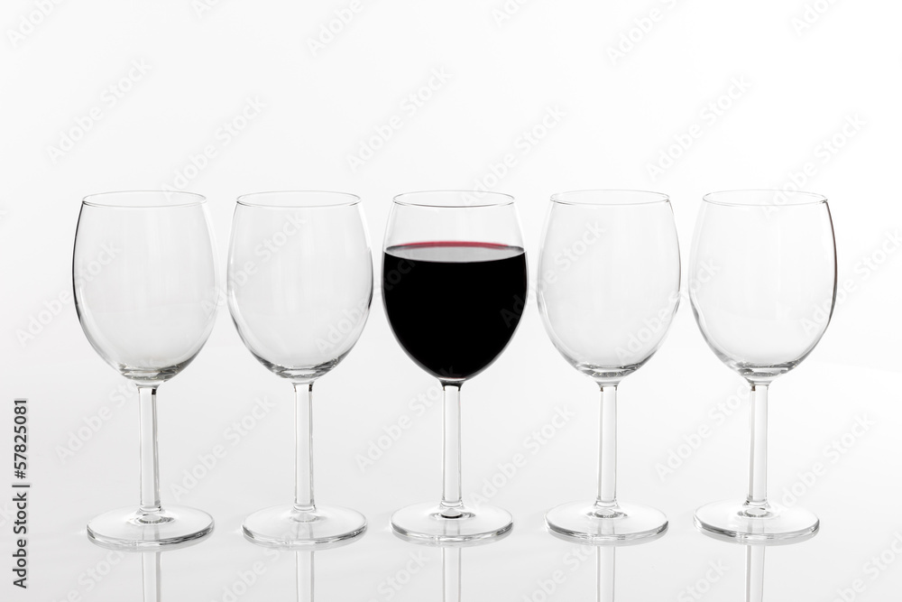 Glass of red wine in a row of empty glasses