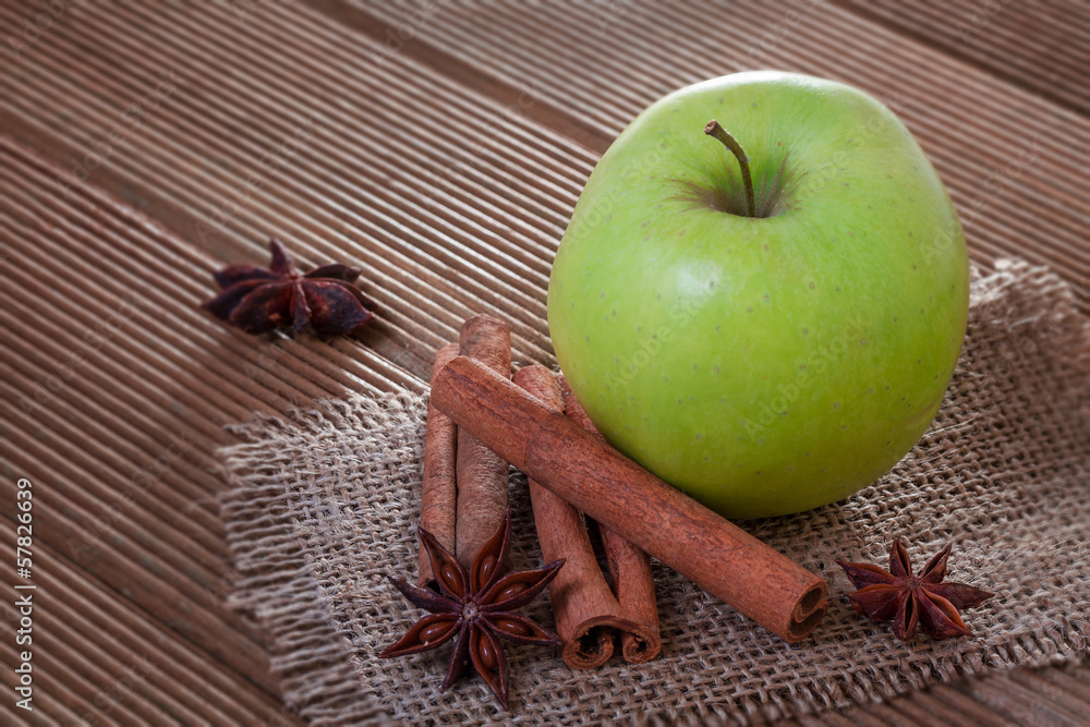 Apple with anise and cinnamon on wooden background