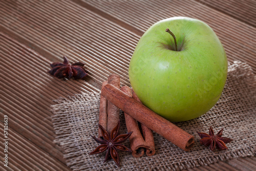 Apple with anise and cinnamon on wooden background