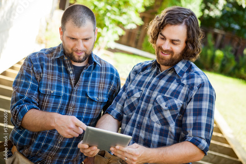 Construction Workers Discussing Project On Digital Tablet