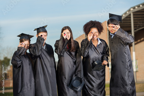 Graduate Students Looking Through Diplomas On Campus