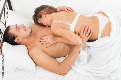 Smiling lovers in bed