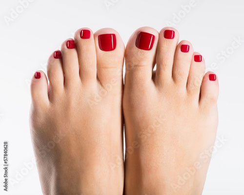 Beautiful female feet with red pedicure