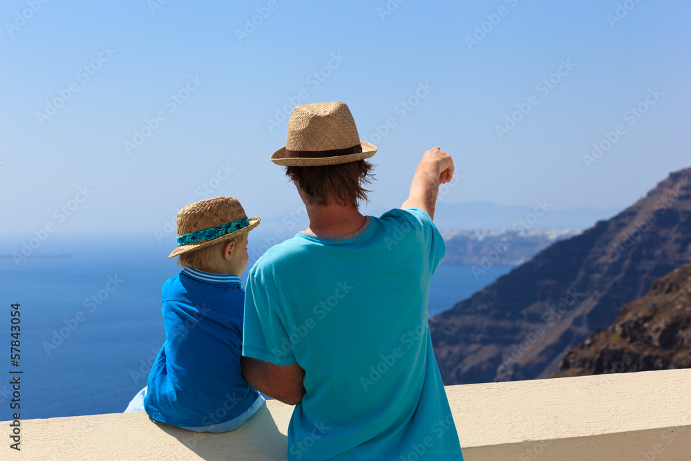father and son looking at Santorini, Greece