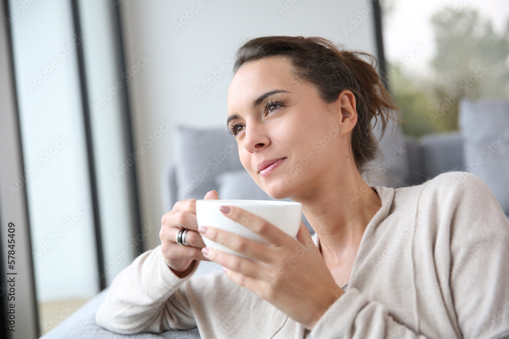 Peaceful woman relaxing at home with cup of tea Peaceful woman relaxing at home with cup of tea