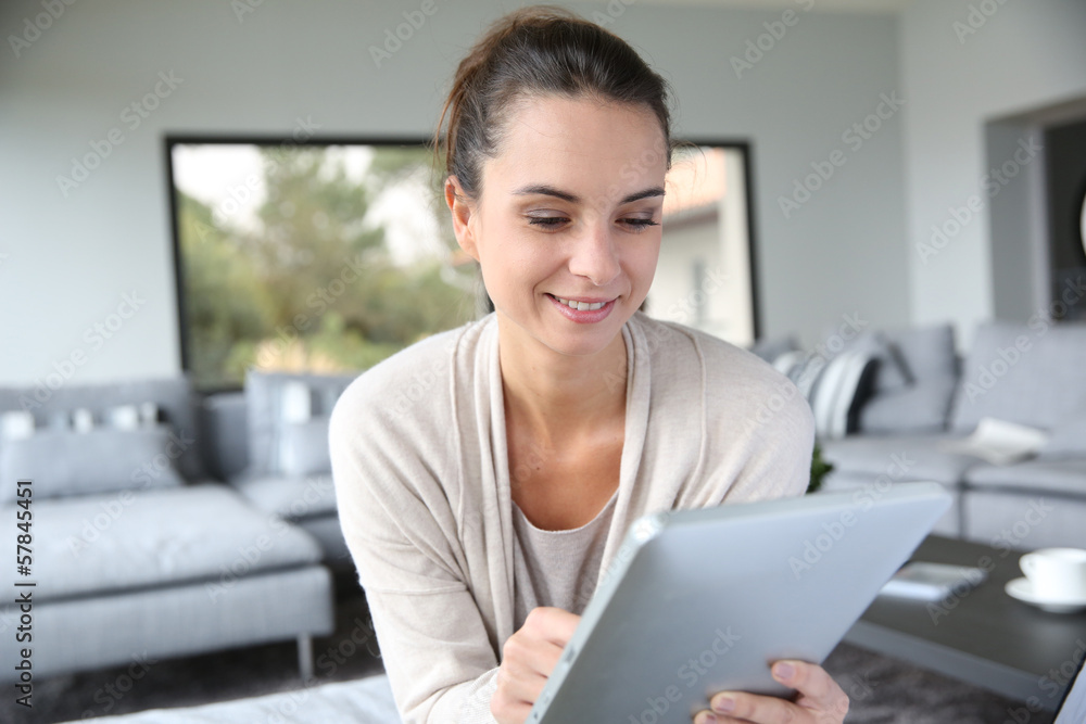 Woman at home websurfing on internet with tablet Woman at home websurfing on internet with tablet