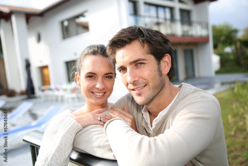 Fototapeta premium Couple standing outside in front of new home