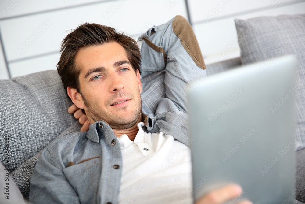 Attractive man at home using digital tablet Attractive man at home using digital tablet