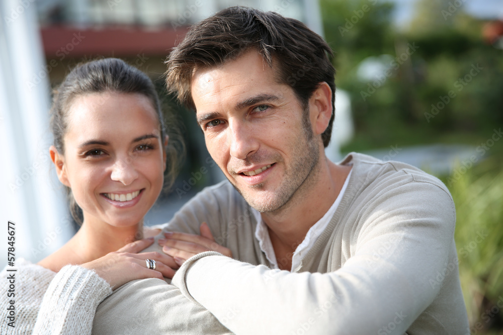 Couple standing outside in front of new home Couple standing outside in front of new home