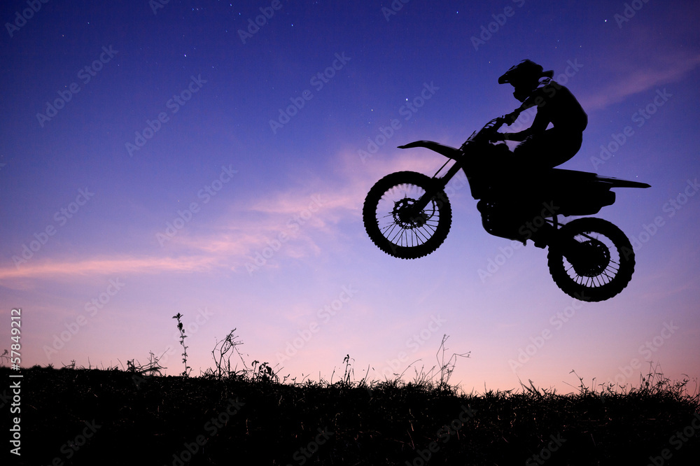 silhouette of a motorcycle racer commits high jump on beautiful silhouette of a motorcycle racer commits high jump on beautiful