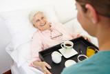 Seniorin im Pflegeheim bekommt Frühstück ans Bett