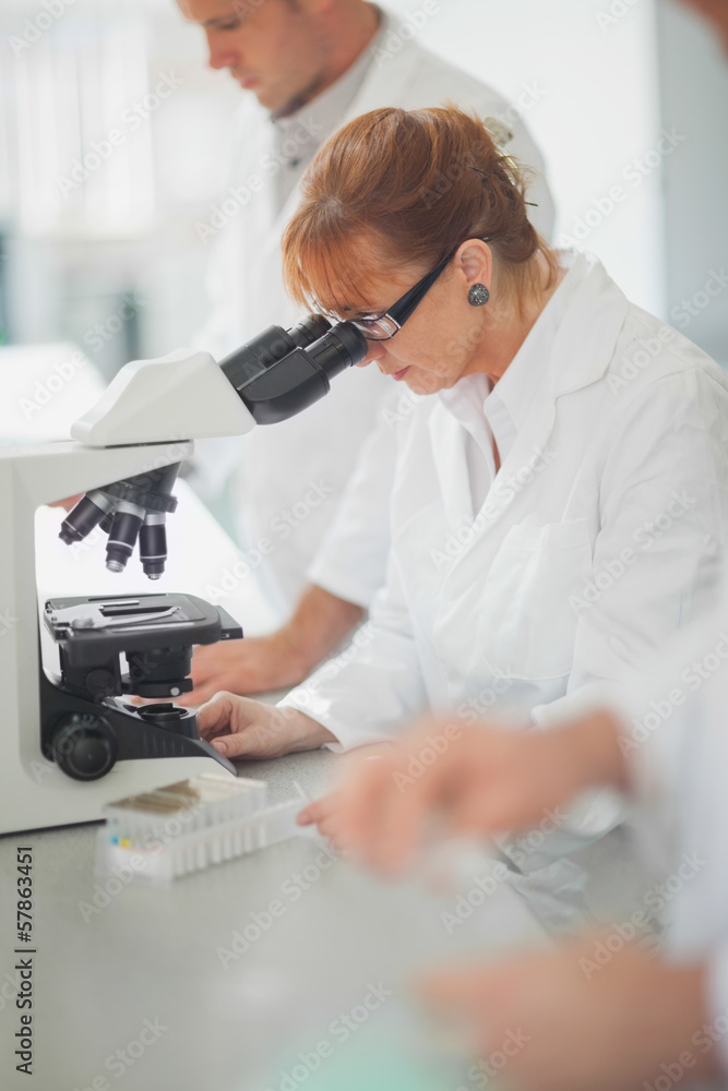 Female scientist looking through a microscope Female scientist looking through a microscope