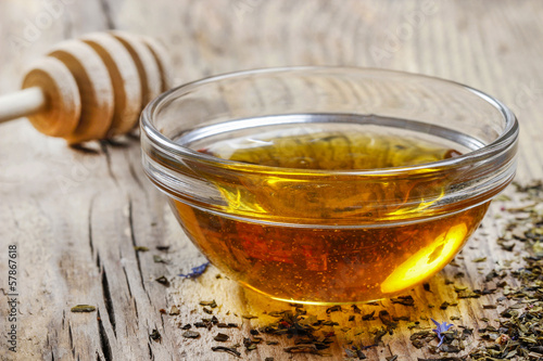 Bowl of honey on wooden table. Symbol of healthy living